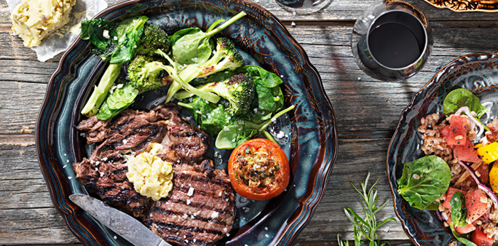 Entrecôte med sardell- och olivsmör, fylld tomat och vitlöksstekt grönt